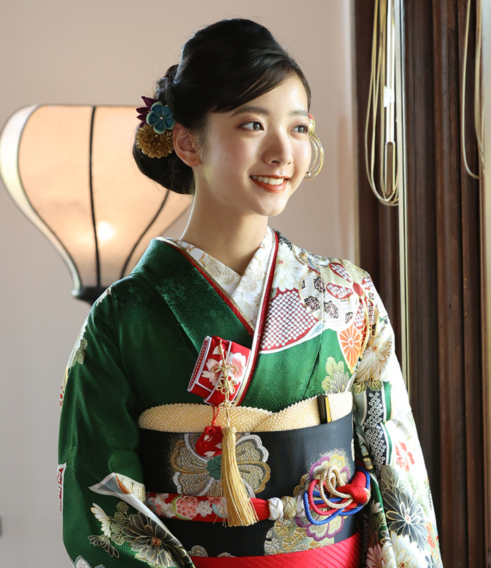 緑の振袖を着て微笑む女性の画像