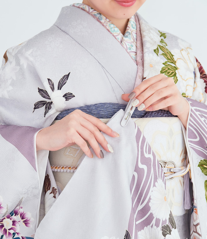 振袖の袖をクリップで帯に留める画像